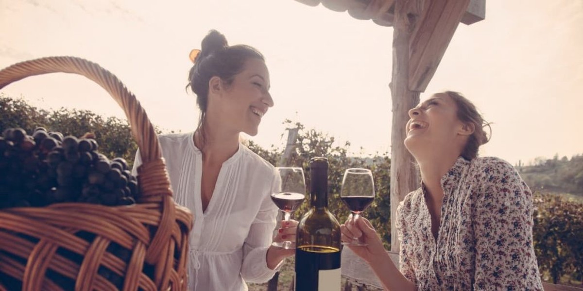 two young women enjoying wine, wondering if pinot noir is sweet.
